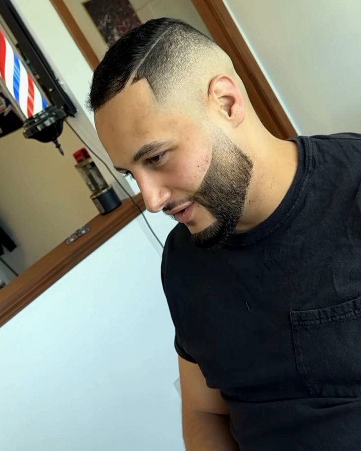 A finished haircut in the chair at Rusty's, barber pole in the background